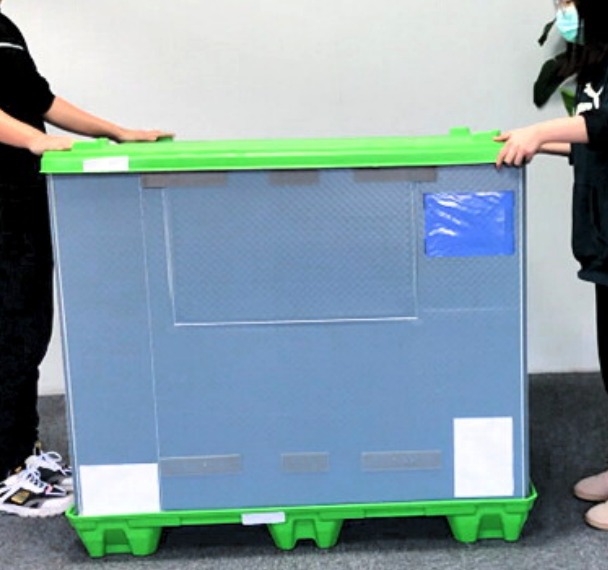Assembled pallet sleeve box: grey sleeve and green lid on the green pallet base.