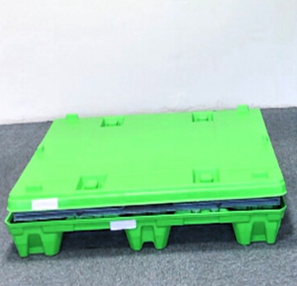 Collapsed sleeve box folded flat on the pallet base with the lid closed.