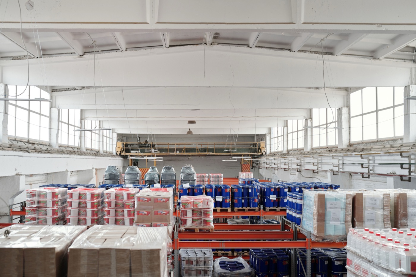 Interior of a warehouse with organized shelving and stacked pallets.